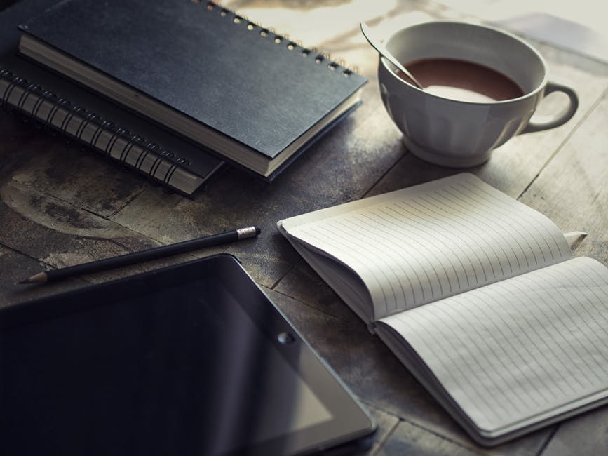 a notebook an ipad and a pencil on the table