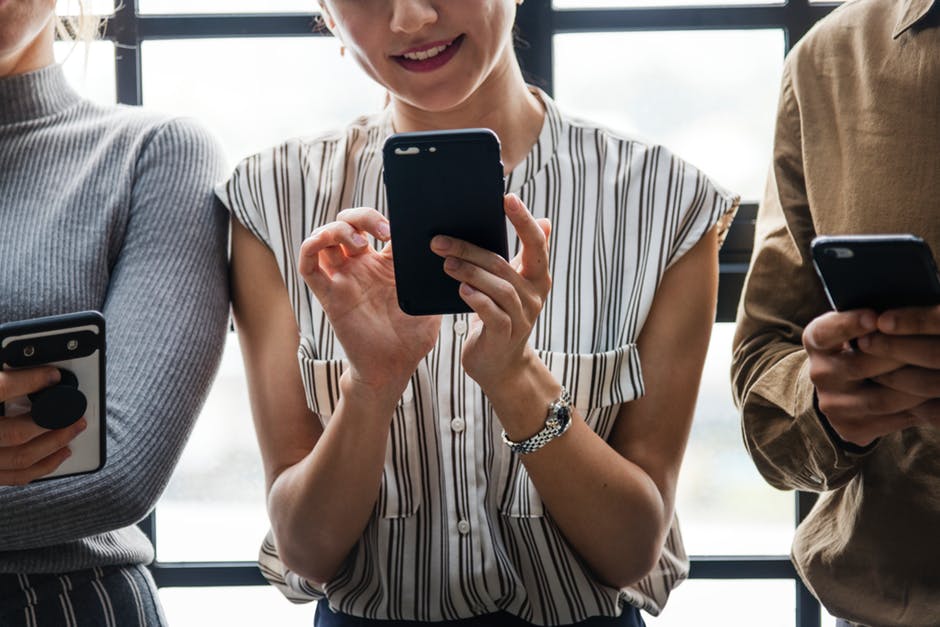 a woman holding her phone sitting with two people